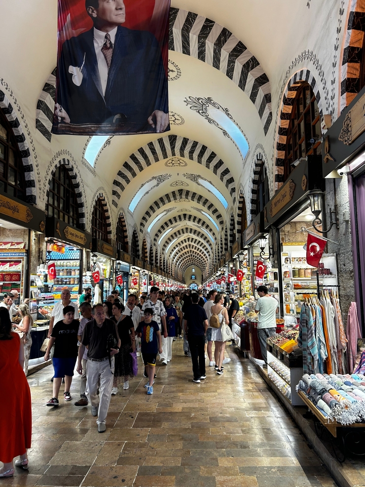 Marché couvert bondé avec plafond voûté et drapeaux turcs.