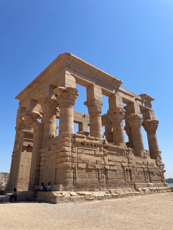 Ancient columns of a temple under a clear sky.