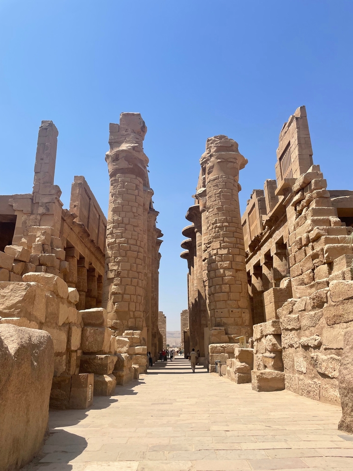 Ancient columns and ruins under a blue sky.