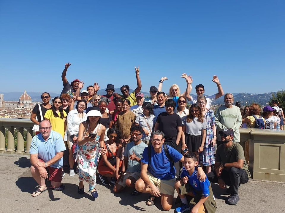 Grand groupe de personnes posant ensemble avec un paysage urbain en arrière-plan.