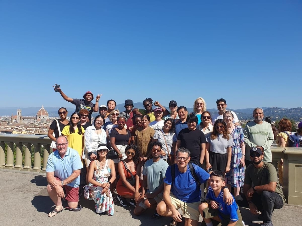 Grand groupe de personnes posant avec un paysage urbain en arrière-plan à nouveau.