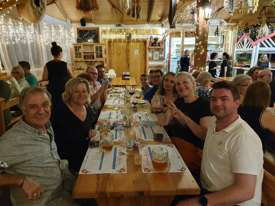 Groupe de personnes qui dînent ensemble dans une atmosphère festive.