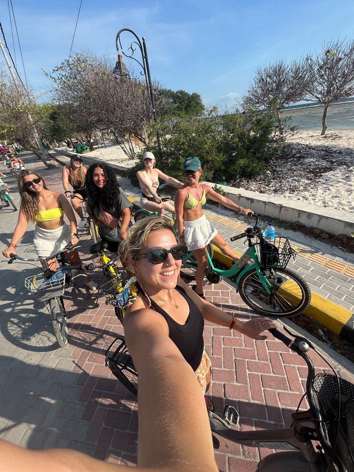 A group of women biking along a beachfront path.