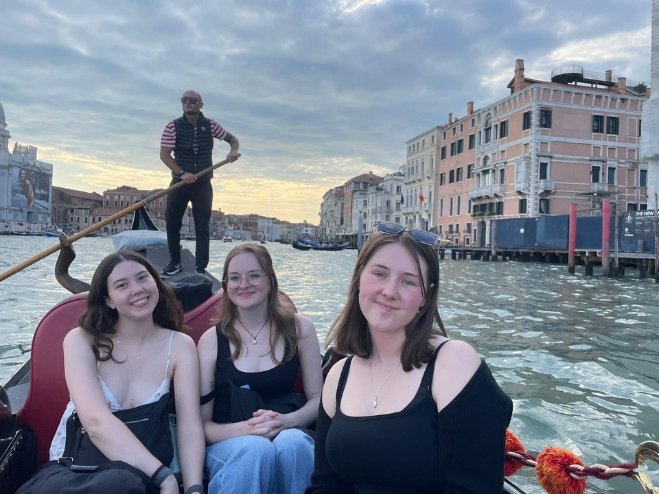 A group of friends on a gondola ride in Venice.