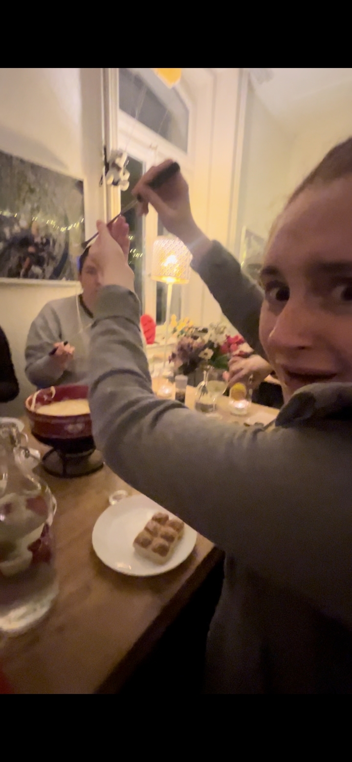 People enjoying a fondue meal at a dinner table.
