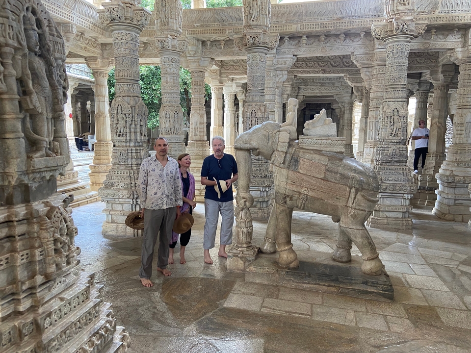 Des gens à l'intérieur des intérieurs de marbre sculptés de manière complexe d'un temple.