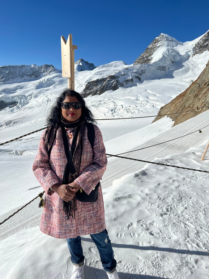 Femme posant dans une région montagneuse enneigée.