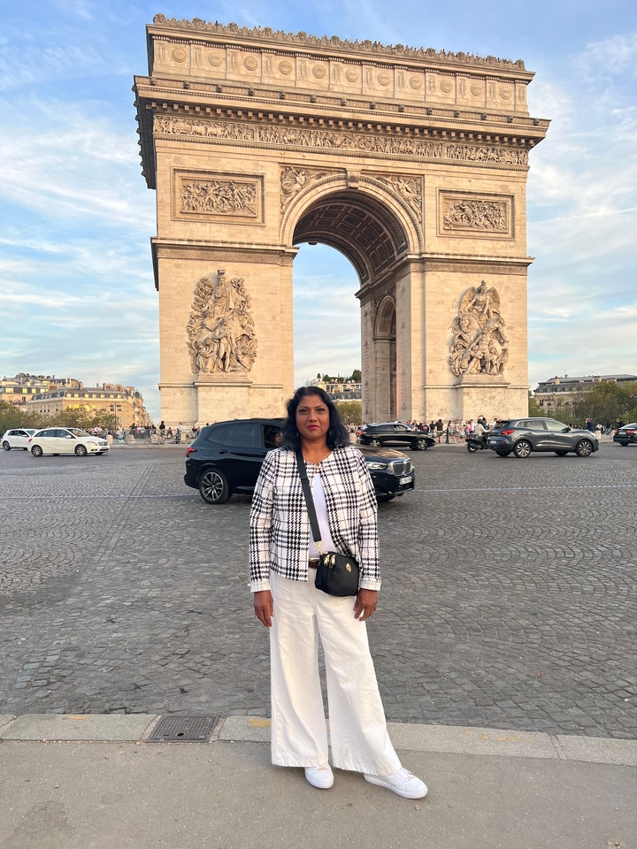 Femme debout devant l'Arc de Triomphe à Paris.