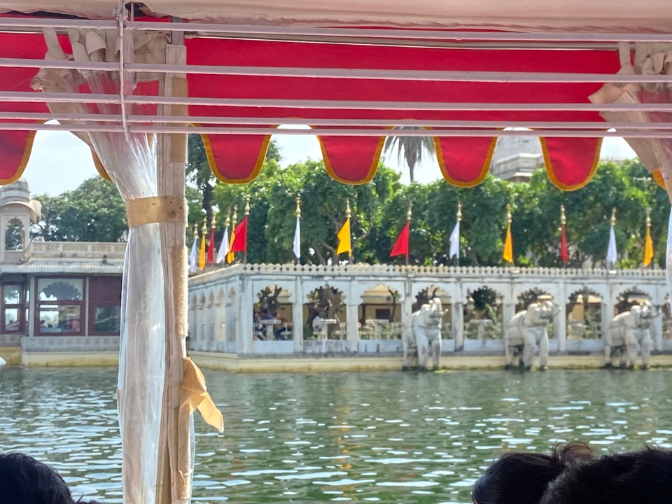 Pavillon coloré au bord de l'eau avec des statues d'éléphants.
