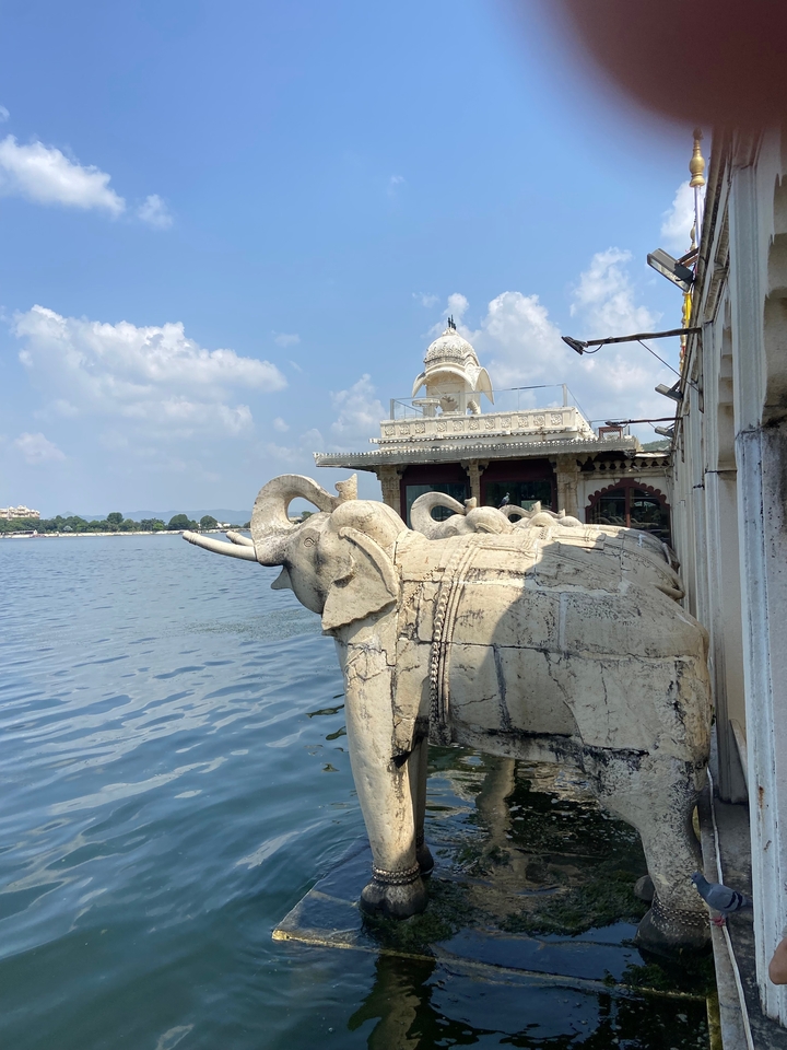 Sculptures d'éléphants en pierre près d'un pavillon au bord du lac.