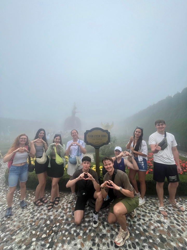 Gruppe von Menschen, die in einer nebligen Gartenkulisse posieren.