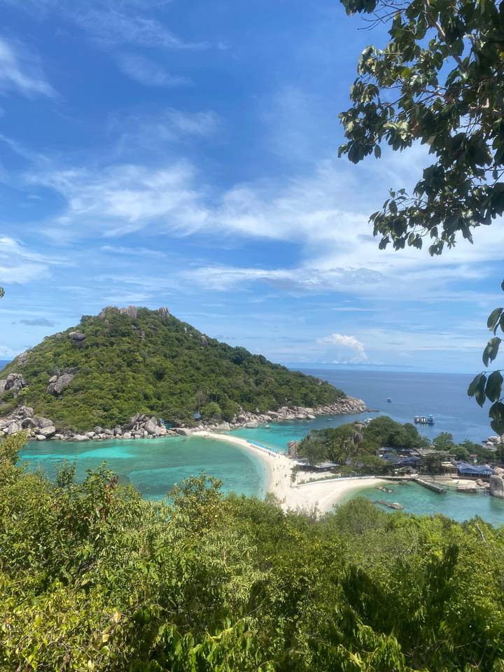 A postcard view over turquoise bays and the sandbar connecting a lush little island to the mainland.