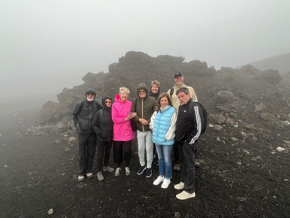 Group of people on a rocky landscape under overcast skies.