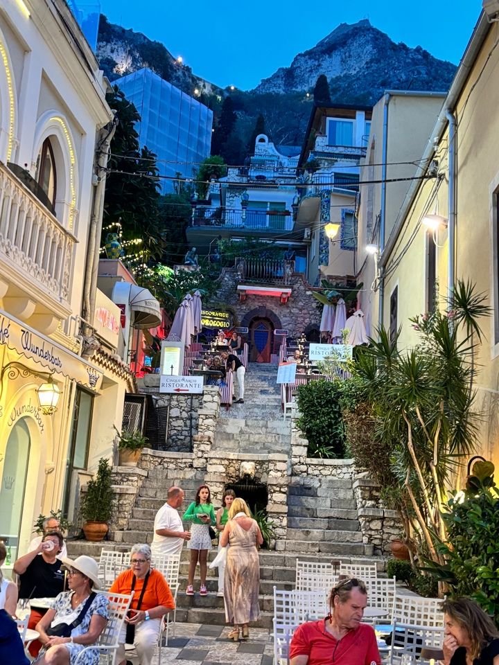 Outdoor staircase restaurant at night with lights.