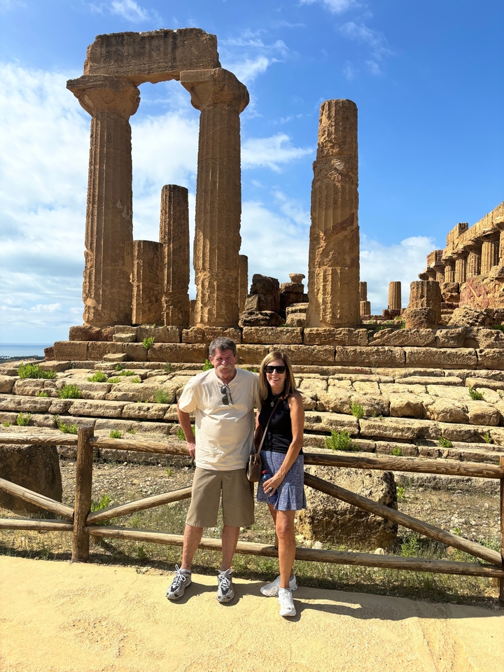 Two people posing in front of ancient temple ruins.