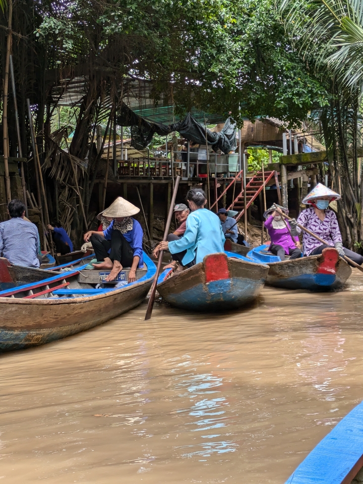 People in traditional boats navigating a waterway.