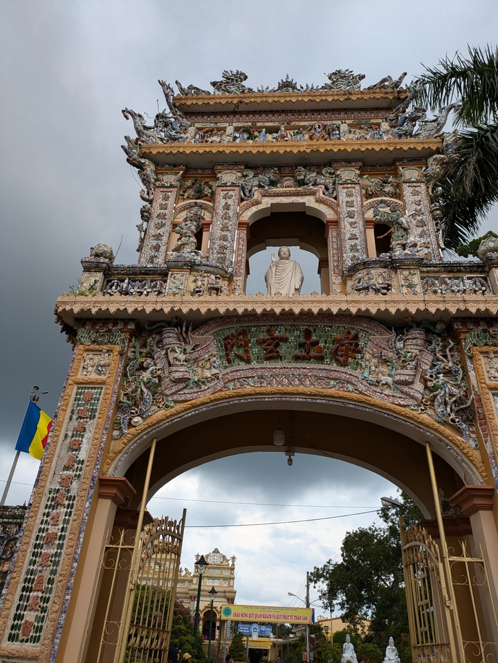 Ornate temple gate with detailed carvings and a statue.