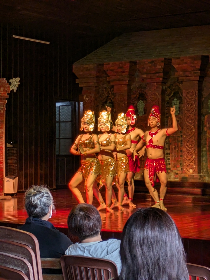 Traditional dancers performing on stage in colorful costumes.