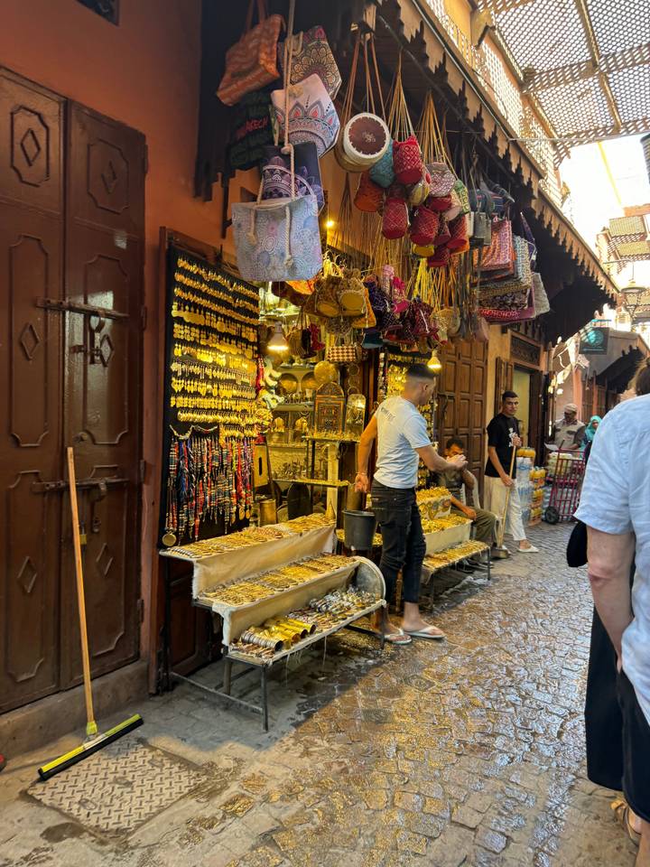 Étal de marché avec des textiles et des marchandises colorés.