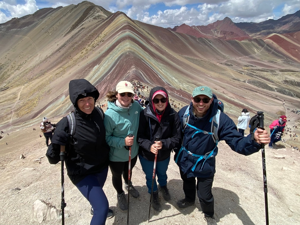 Groupe de randonneurs au Rainbow Mountain avec un paysage coloré.