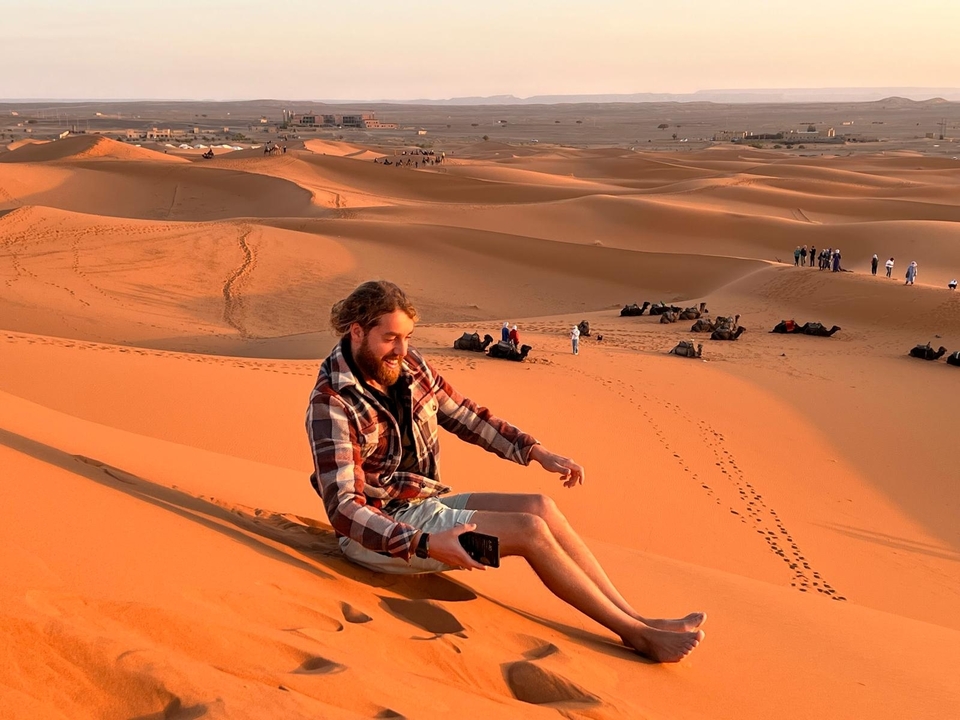 Homme glissant sur les dunes de sable au coucher du soleil.