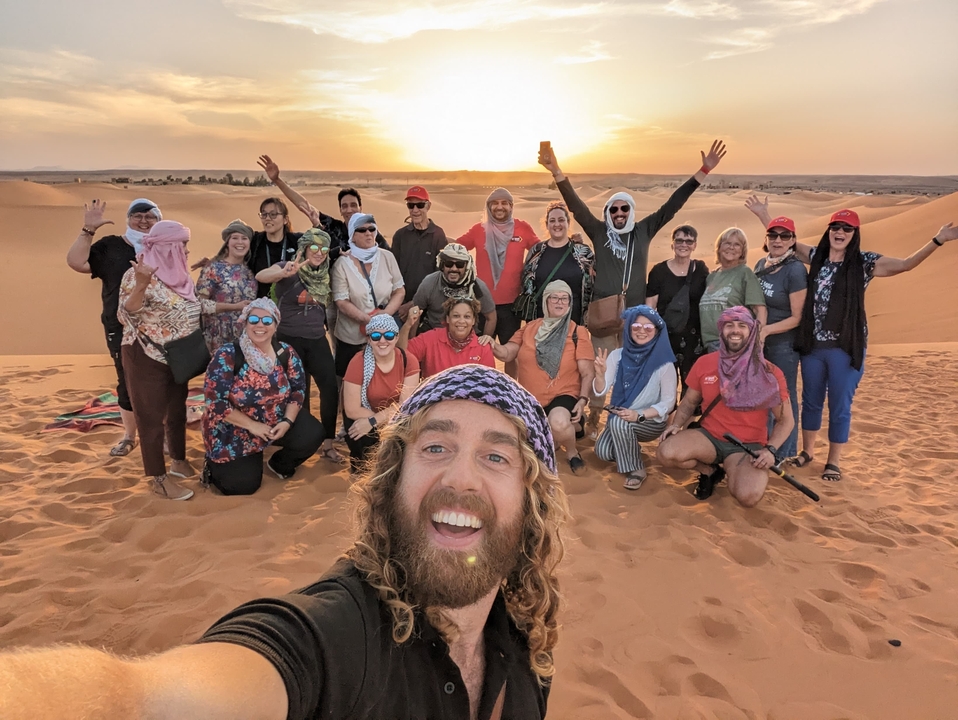 Photo de groupe dans le désert avec des personnes portant des foulards.