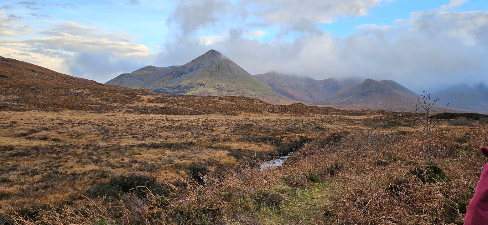 Expansive view of mountains under cloudy skies.