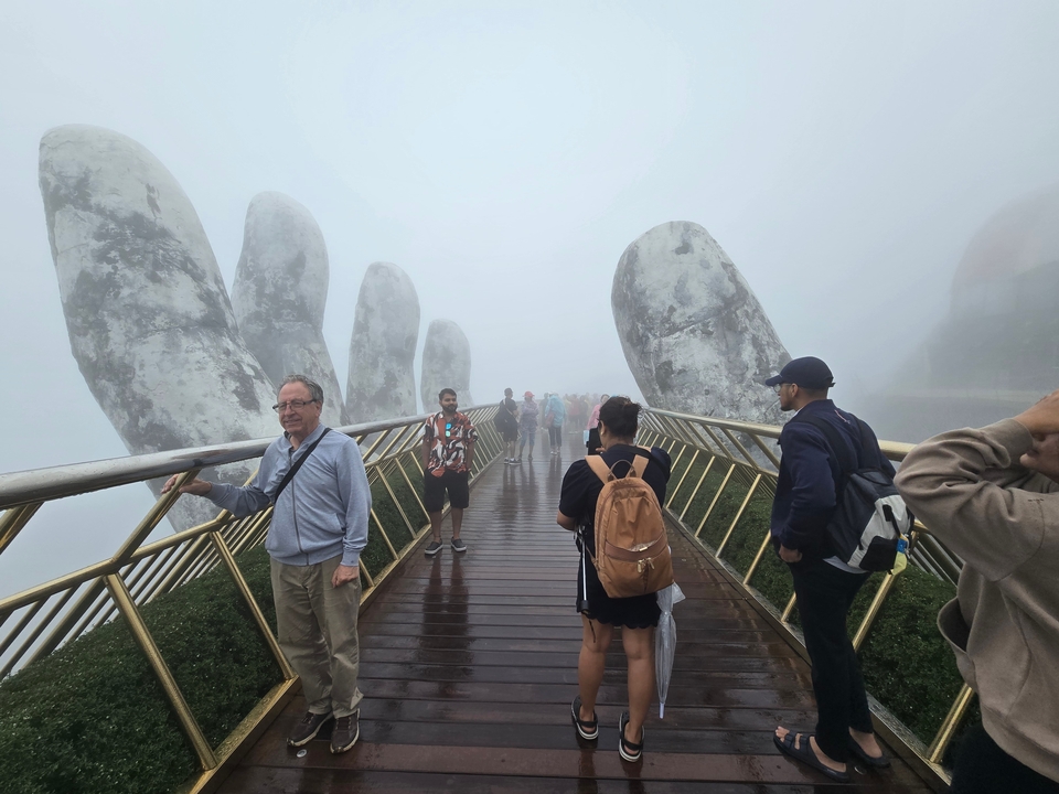 Tourists on the Golden Bridge in foggy conditions.