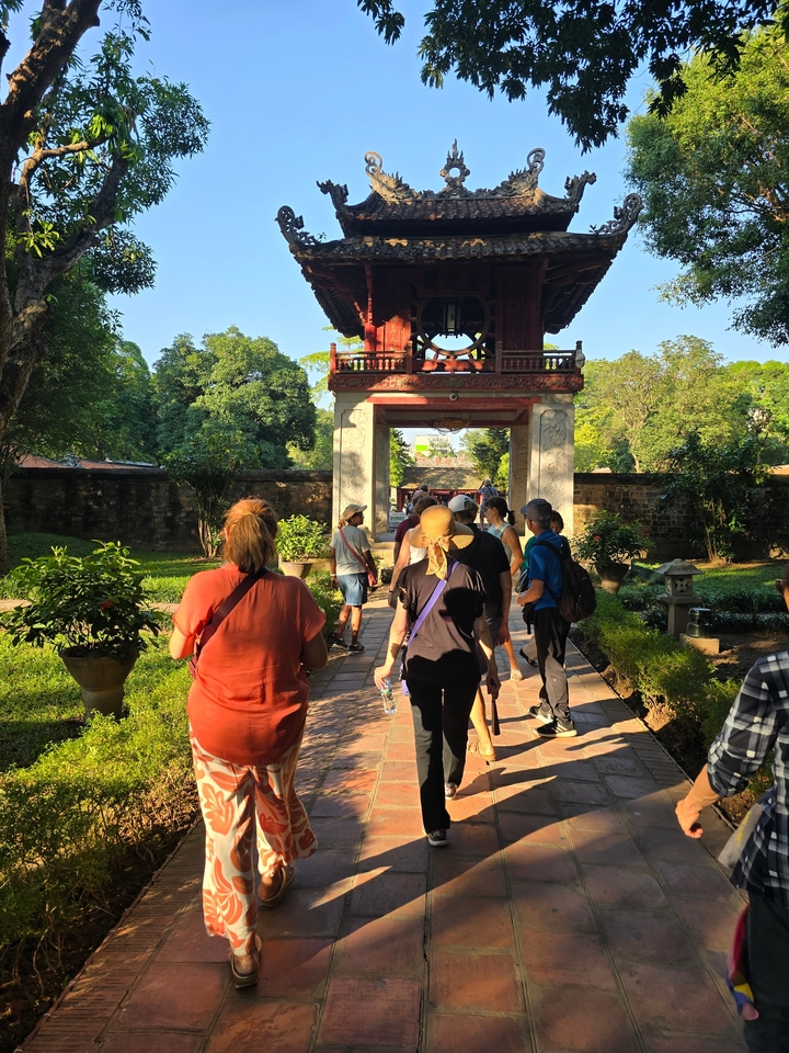 Group of tourists walking through a temple garden.