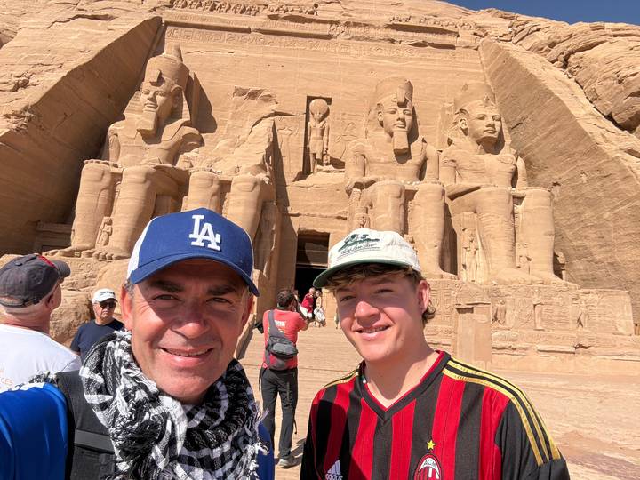 Deux personnes devant des statues sculptées dans la roche.