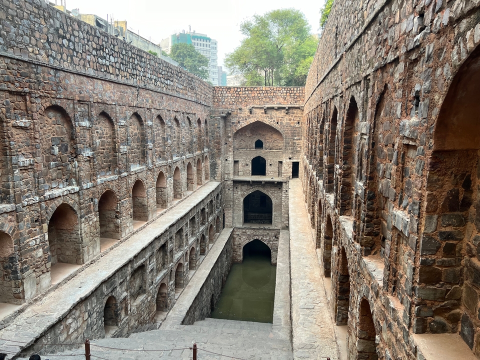 Stepwell with layers of stone walls and arches.