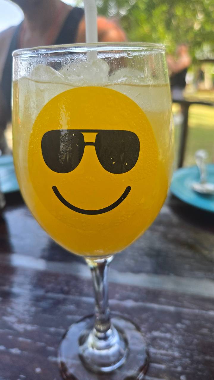 Gros plan d'un visage souriant sur un verre.