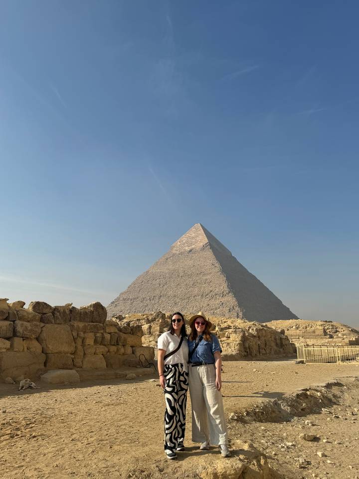 Two people posing with the Great Pyramid behind.