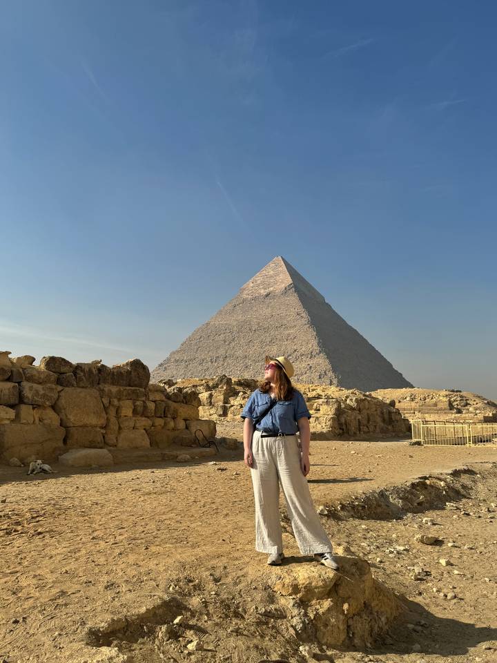Woman standing in front of a pyramid.