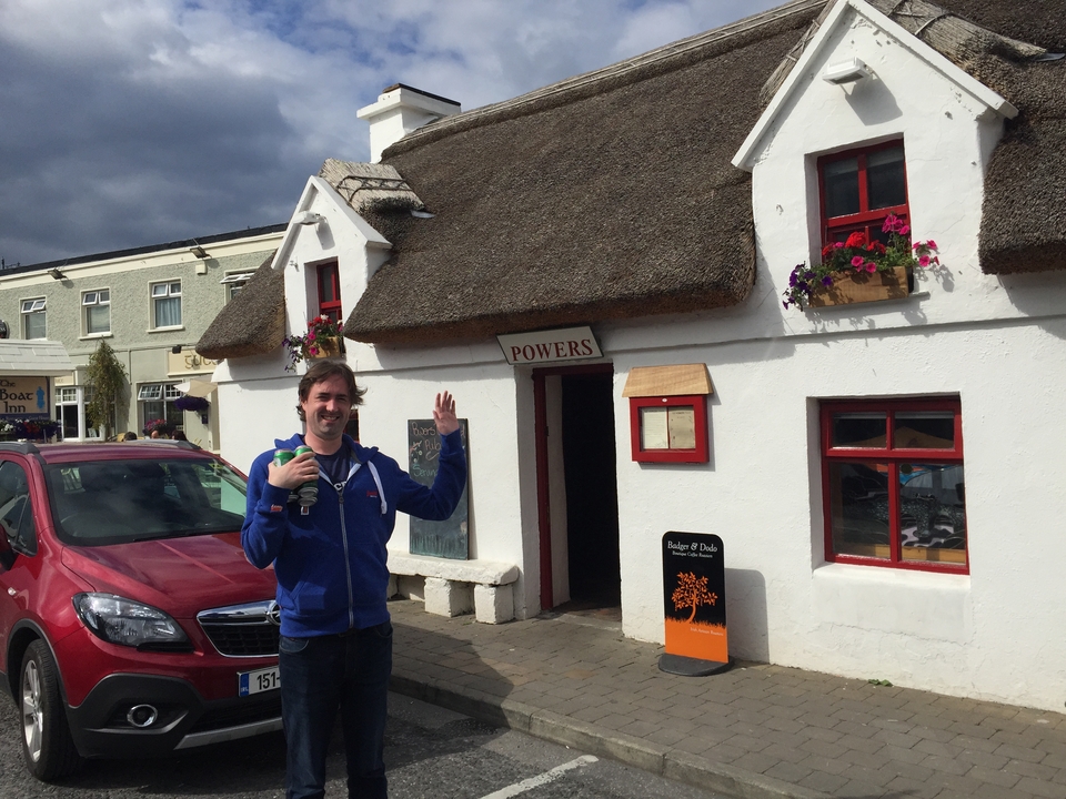 Personne debout devant un pub traditionnel au toit de chaume