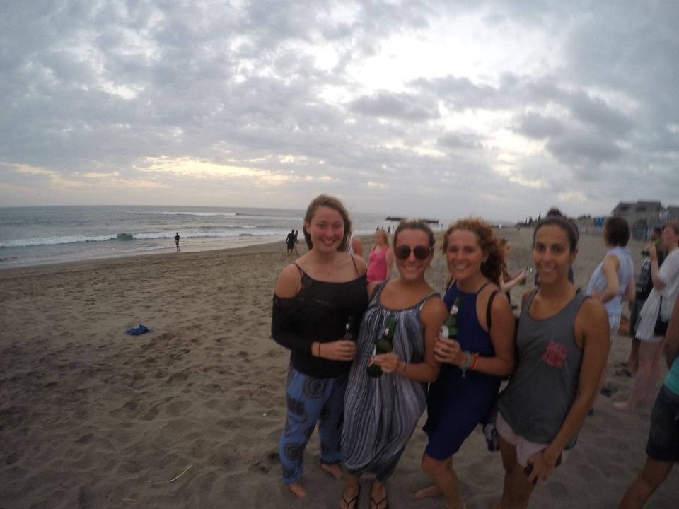 Group of people enjoying a beach with a sunset backdrop