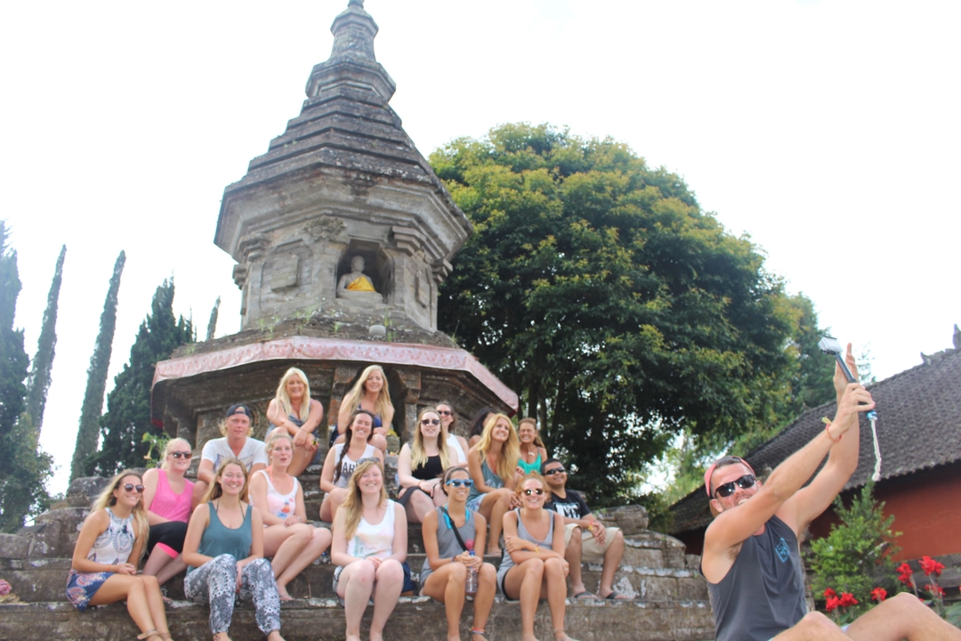 Large group selfie in front of a temple