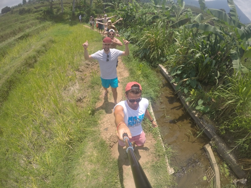 Group of friends hiking in a rice field.