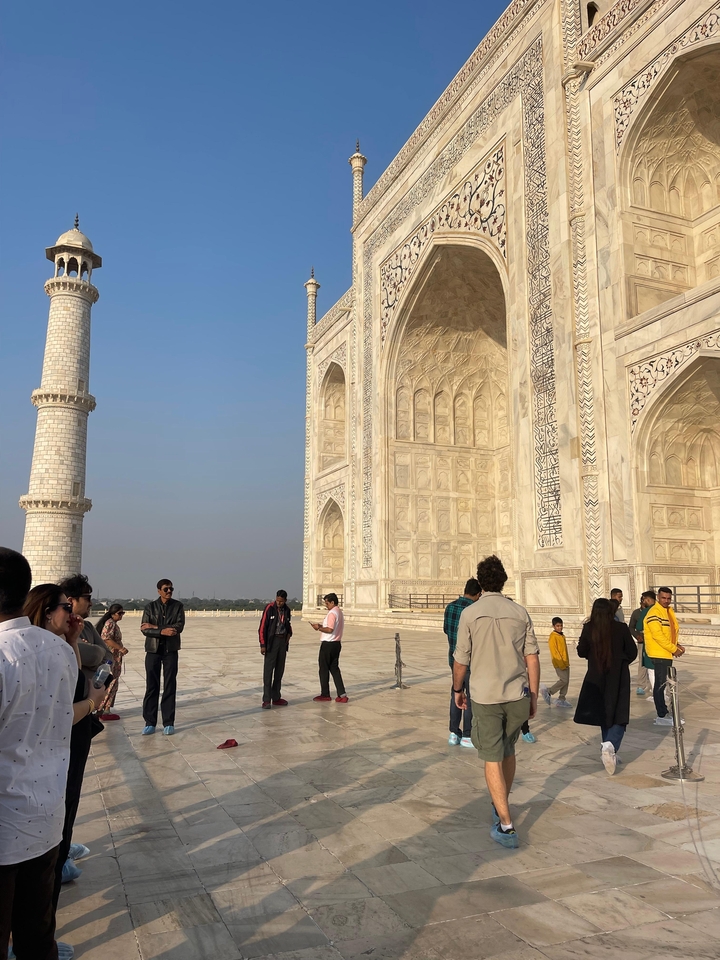Visiteurs devant la magnifique façade de marbre du Taj Mahal.