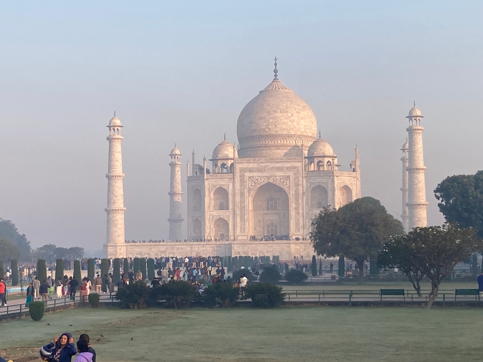 Taj Mahal with visitors in a garden setting.