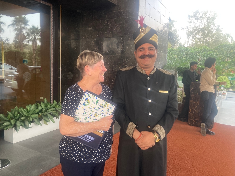 Two people smiling and talking with a hotel staff member.