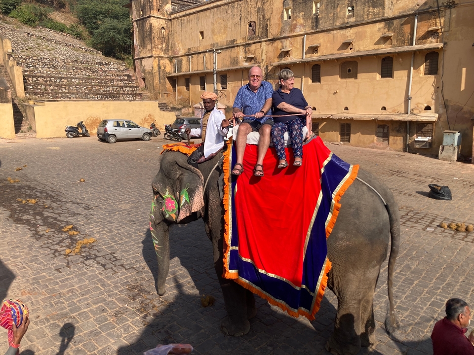 Tourists riding an elephant in a historic location.