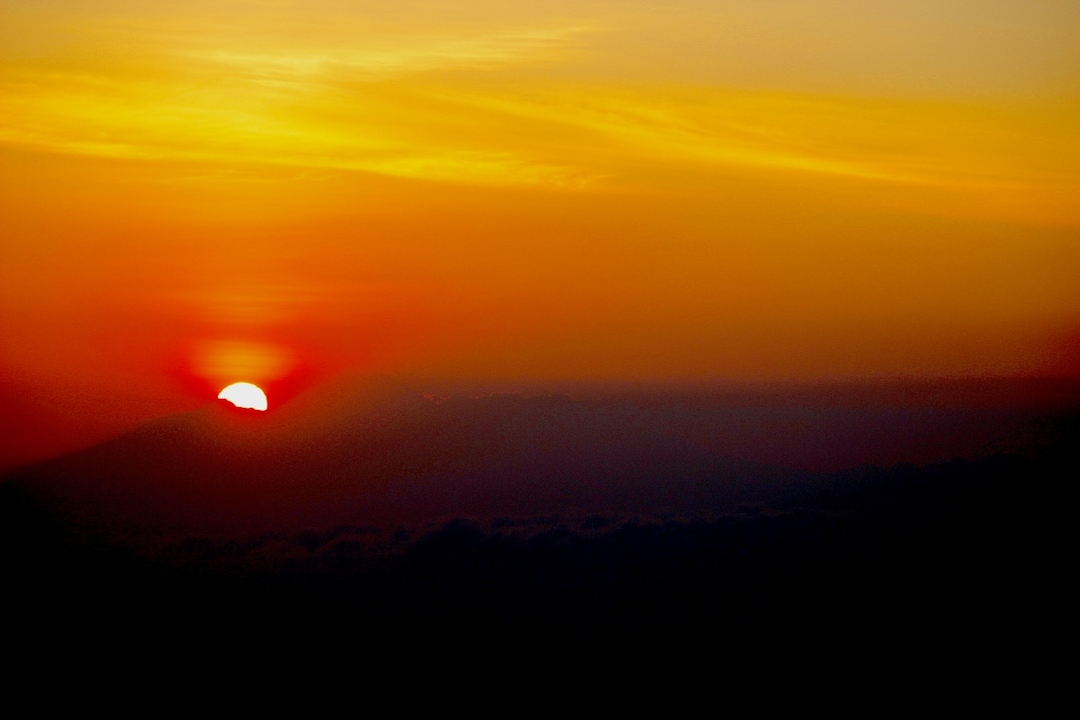 Sunrise with mountains silhouetted in the background.