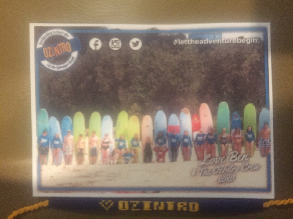 Blurry photo of people with colorful surfboards and overlay text.