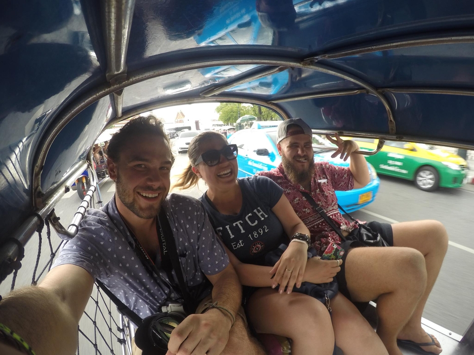 Three people enjoying a ride in a tuk-tuk.