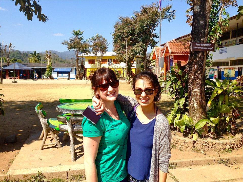 Two women smiling in a sunny outdoor setting.