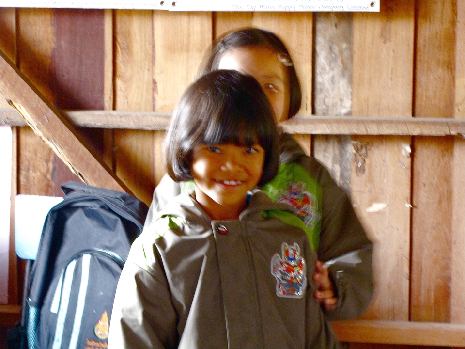 Children smiling indoors with a playful vibe.