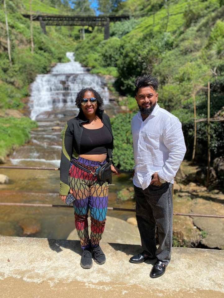 Un couple posant devant une cascade.