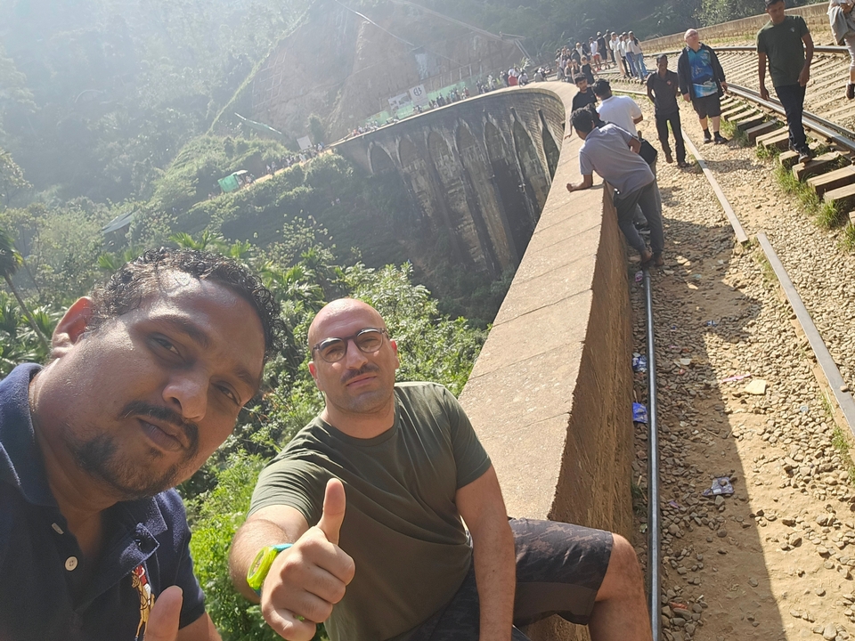 Deux personnes assises sur un pont de chemin de fer.