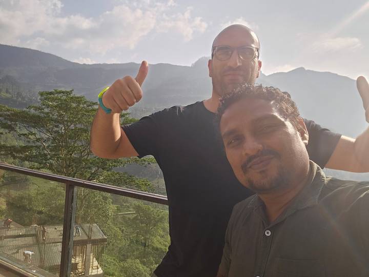 Deux hommes faisant un pouce levé avec un arrière-plan montagneux.